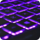 Beleuchtete Computertastatur in violettem Licht.
